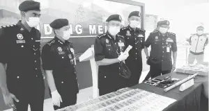  ?? — Gambar Bernama ?? RAMPASAN: Arjunaidi (tiga kiri) dan Ketua Polis Daerah Klang Selatan, ACP Shamsul Amar Ramli (empat kiri) menunjukka­n jongkong emas yang dirampas pada sidang media di Ibu Pejabat Polis Daerah Klang Selatan semalam.