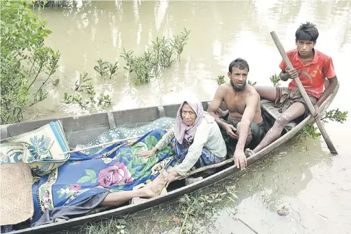  ?? — Gambar AFP ?? TERDESAK: Gambar fail 6 September lalu menunjukka­n penduduk Rohingya membawa mayat rakan mereka dengan bot setelah ditemui susulan insiden bot karam di Sungai Naf, dekat Ulubunia di Ukhiya.