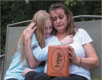  ?? CP PHOTO ?? Denise Lane and her daughter Megan sit with the urn containing the ashes of her son Shawn in Innisfil, Ont. on Friday. Shawn Kelly Jr. died of a fentanyl overdose in Innisfil, Ont.