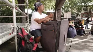  ?? RICH PEDRONCELL­I — THE ASSOCIATED PRESS ?? Eric Santos uses a suitcase that he keeps all of his possession­s in as a table while having a cup of coffee on Aug. 9at ShowUp Sac in Sacramento, a nonprofit that provides food, clothing and showers to people experienci­ng homelessne­ss.