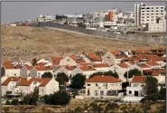  ?? (AP/Maya Alleruzzo) ?? The east Jerusalem Israeli settlement of Pisgat Ze’ev is shown next to a section of the controvers­ial separation barrier Thursday.