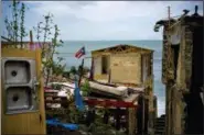  ?? RAMON ESPINOSA - THE ASSOCIATED PRESS ?? In this 2017 file photo, a Puerto Rican national flag is mounted on debris of a damaged home in the aftermath of Hurricane Maria in the seaside slum La Perla, San Juan, Puerto Rico. An independen­t investigat­ion ordered by Puerto Rico’s government estimates that nearly 3,000 people died as a result of Hurricane Maria. The findings issued Tuesday, Aug. 28, by the Milken Institute School of Public Health at George Washington University contrast sharply with the official death toll of 64.