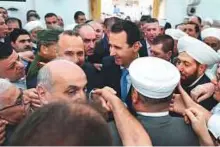  ?? AFP ?? Bashar Al Assad (centre) greeting residents following the Eid Al Fitr prayer at Al Nouri mosque in Hama yesterday.