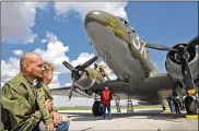  ?? BILL LACKEY / STAFF ?? Jonathan Dalton and his son, Rowan, watch as the flight crew of the That’s All, Brother, a C47 airplane, refuel the aircraft Monday at Grimes Field in Urbana.