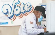  ?? Lea Suzuki / The Chronicle ?? Larry McKinney completes his ballot at a polling place on Fillmore Street in S. F., but most California­ns mailed their ballots.