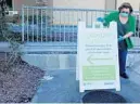  ?? JOE CAVARETTA/SOUTH FLORIDA SUN SENTINEL ?? Lisa Wiley of Walmart sets up a sign for the opening of the store’s new drive-up, selftestin­g service offered by Quest Diagnotics on June 16 in Boynton Beach.