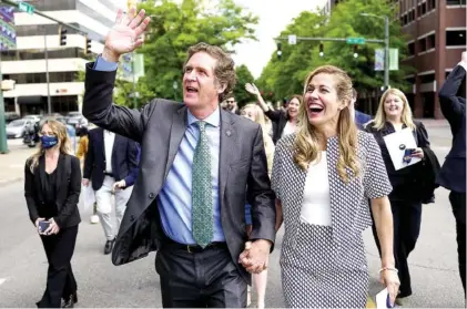  ?? STAFF PHOTO BY C.B. SCHMELTER ?? Mayor Tim Kelly, left, and his wife Ginny Kelly, react as supporters cheer as they make their way to City Hall down Broad Street after Kelly’s inaugurati­on during the One Chattanoog­a ceremony at the Tivoli Theatre on Monday. Kelly is the 66th mayor of Chattanoog­a.