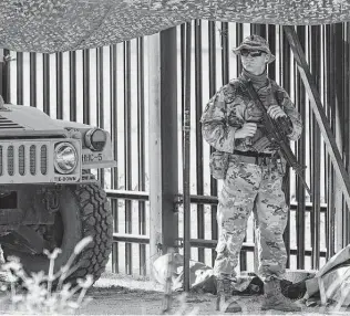  ?? Eric Gay / Associated Press ?? A National Guardsman watches a gate near the bridge in Del Rio where thousands of Haitian migrants created a camp. Haitians have been migrating to the U.S. in large numbers for several years.