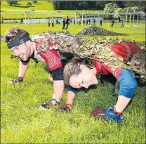  ??  ?? Inseparabl­e: Zayne and Tobias get down and dirty on the 20mile Burghley assault course