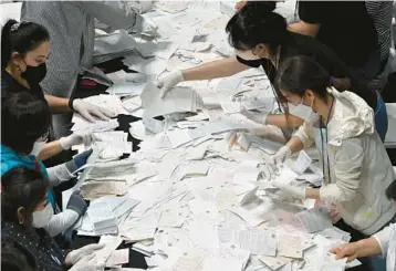  ?? JUNG YEON-JE/GETTY-AFP ?? South Korean election officials sort through and count ballots Wednesday at a gymnasium in Seoul. Voters went to the polls
nationwide in races to elect mayors, governors, local council members and regional education chiefs. President Yoon Sook Yeol’s governing party won 12 of the 17 races for big-city mayors and provincial governors in local elections.