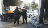  ??  ?? Raquel Bowles, Ukiah Food Bank coordinato­r, and volunteer Starr Poindexter unload a truck with donations from the two Starbucks in town, Costco, Raley’s and Little Caesars Pizza.