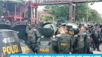  ?? — AFP ?? JAYAPURA: Indonesian riot police take positions at a university in provincial capital Jayapura as protests break out in the restive region.