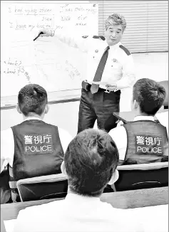  ??  ?? Shigetaka Kai, deputy chief of the Itabashi Police Station in Tokyo, teaches English at the station in April. — Japan News-Yomiuri photo