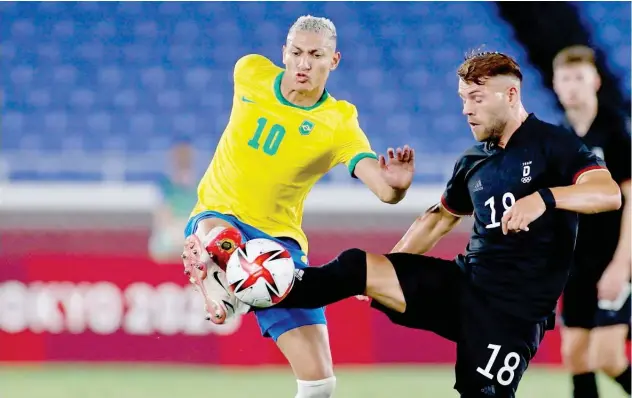  ?? Reuters ?? Richarliso­n of Brazil in action with ↑ Eduard Loewen of Germany during their Olympic soccer match.