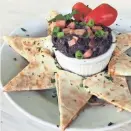  ?? BEANS & BARLEY ?? Beans &amp; Barley's black bean dip starts with dried beans and is served with cheese quesadilla­s.