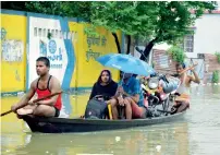  ?? PTI ?? Flood-affected people shift to safer places in a boat at a street in Muzaffarpu­r district, Bihar. —
