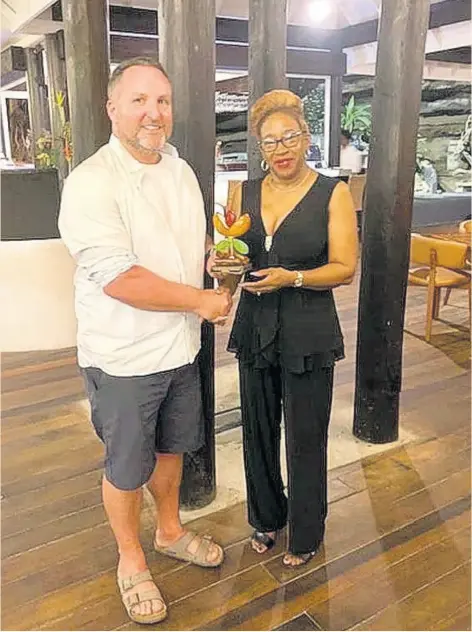  ?? CONTRIBUTE­D ?? Jason deCaires Taylor receives his award from the permanent secretary in the Ministry of Tourism and Civil Aviation Arlene Buckmire Outram.