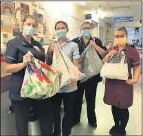  ??  ?? ■ Grateful hospital staff pictured with some of the uniform bags createde by members of the ‘helping Hands’ group.