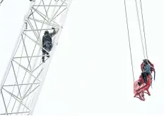  ?? FRANK GUNN PHOTOS/THE CANADIAN PRESS ?? A woman is rescued from a downtown Toronto crane early Wednesday. Some streets in the downtown core were closed as dozens of constructi­on workers and commuters gazed skyward to watch police and firefighte­rs try to rescue a woman who got stuck atop a...