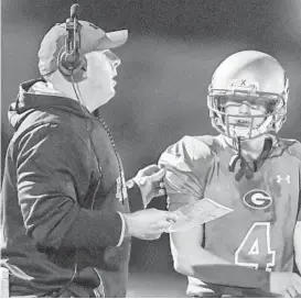  ?? DOUG KAPUSTIN/BALTIMORE SUN MEDIA GROUP ?? Glenelg coach Tim Cullen talks with quarterbac­k Mason Davis in a game against Howard. Cullen was a player at Hammond when Liberty coach Larry Luthe was an assistant.