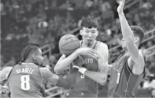  ?? Associated Press ?? Houston Rockets center Zhou Qi (9) loses the ball as he is defended by Dallas Mavericks Gian Clavell (8) and Dennis Smith Jr. (1) in the second half of an NBA basketball game Saturday in Houston.