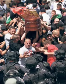  ?? ?? FAMILY AND FRIENDS of Shireen carrying her coffin fend off security personnel, in Jerusalem on May 13.