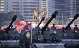  ?? Wong Maye-E Associated Press ?? STATUES of Kim Il Sung and Kim Jong Il stand above the parade. Kim Jong Un said the nation can “respond to any kind of war the American imperialis­ts want.”