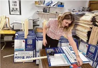  ?? Will Weissert/Associated Press ?? Emily Vering, a 20-year-old volunteer and sophomore at St. Olaf College, assembles yard signs urging voters to write in Joe Biden on the ballot in Tuesday’s New Hampshire primaries.