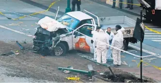  ?? DON EMMERT/ AFP/ GETTY IMAGES ?? Investigat­ors inspect a truck that plowed into a bike path in Lower Manhattan on Tuesday.