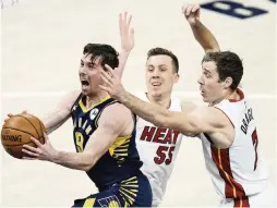  ?? AJ MAST AP ?? Heat defenders Duncan Robinson, center, and Goran Dragic surround Pacers guard T.J. McConnell as he drives to the basket in the first half Wednesday at Indiana.