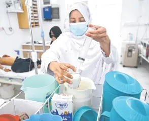  ?? ?? A staff preparing milk formula patients in the malnutriti­on ward at the Boost Hospital.