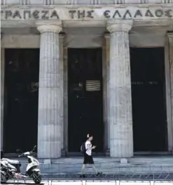  ??  ?? THESSALONI­KI: A man passes the Bank of Greece yesterday in Thessaloni­ki. Greece’s debt mountain stands at a towering 179 percent of annual output, the legacy of a crisis that brought panic to the markets and nearly forced the country out of the euro....