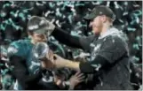 ?? FRANK FRANKLIN II — THE ASSOCIATED PRESS ?? Philadelph­ia Eagles quarterbac­k Carson Wentz, right, hands the Vincent Lombardi trophy to Nick Foles after winning the NFL Super Bowl 52 football game against the New England Patriots, Sunday in Minneapoli­s. The Eagles won 41-33.