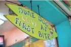  ?? PROVIDED ?? A sign hangs from a doorpost at the Dune Dog Cafe restaurant in Jupiter.