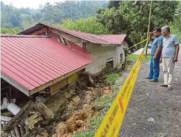  ?? BERNAMA PIC ?? Addehap Shaaban, 73, (right) and his son, Khairul Saiful, 38, looking at their landslide-hit home in Kampung Orang Asli, Batu 12, Gombak, yesterday.