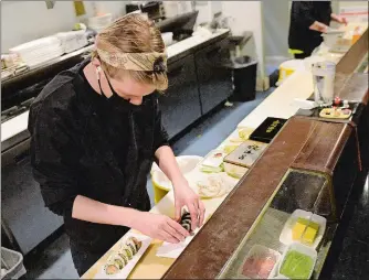  ?? DANA JENSEN THE DAY ?? Sushi sous chef Jack MacDonald works behind the sushi bar Friday at the restaurant Go Fish in Mystic. Jon Kodama is the owner of the restaurant­s Go Fish and Steak Loft in Mystic, Breakwater in Stonington Borough and the seasonal Cafe Marina in Norwich.
