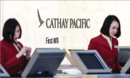  ?? ANTHONY WALLACE/AFP ?? Cathay Pacific employees work at their counters at the internatio­nal airport in Hong Kong.