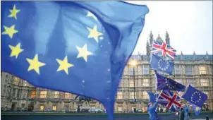  ?? DANIEL LEAL-OLIVAS/AFP ?? Pro-European Union, anti-Brexit demonstrat­ors hold the EU and UK flags outside the Houses of Parliament, in central London, on Monday.