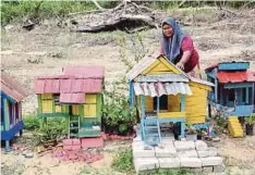  ??  ?? ROBIAH bersedia menjual rumah mini yang dihasilkan­nya daripada bahan terbuang di Kampung Bukit Langsat, Tanjung Bidara.