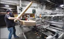  ??  ?? In this file photo, Rob Bondurant, a supervisor at Great Southern Industries, a packaging company, loads up a finishing machine in the Jackson, Mississipp­i facility. (AP)