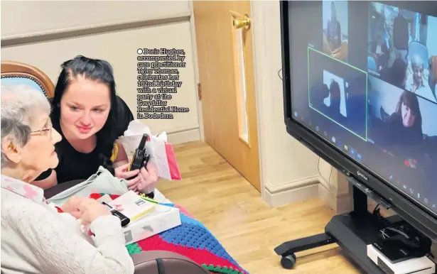  ??  ?? ● Doris Hughes, accompanie­d by care practition­er Tyler Thomas, celebrates her 102nd birthday with a virtual party at the Gwyddfor Residentia­l Home in Bodedern