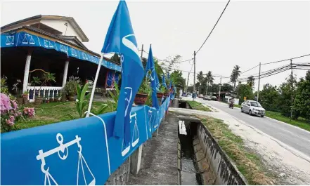  ??  ?? All decked in blue: Barisan flags line a road in Sungai Buloh for the upcoming general election.