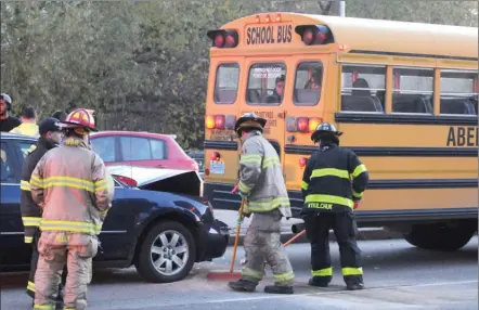  ?? Okanagan Weekend file photo ?? Kelowna firefighte­rs clean up after a car struck the back of a school bus. The Central Okanagan school district says it has no plans to add seatbelts to local school buses.
