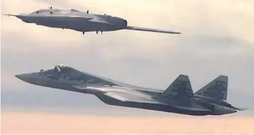  ??  ?? Capture d'écran de la vidéo du vol du S-70B Okhotnik avec un Su-57 fin septembre 2019. Le drone n'est encore qu'un démonstrat­eur dont l'architectu­re va évoluer, notamment au niveau de la tuyère, qui sera optimisée pour une réduction de la signature infrarouge. Des essais de largage d'armement devraient avoir lieu en 2020. (© D.R.)