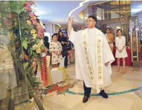  ??  ?? Fr. Vic Uy blesses the Yankee Candle flagship store at the Venice Grand Canal Mall in McKinley Hill.