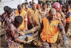  ??  ?? Rescuers carry the body of a victim yesterday after Tuesday’s massive landslide in Rangamati district, Bangladesh. —AP