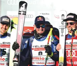  ??  ?? Italy’s Dominik Paris, centre, sits with Switzerlan­d’s Urs Kryenbuehl, left, and Beat Feuz at the finish area of an alpine ski, men’s World Cup downhill, in Bormio Photo: AP
