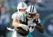  ?? ELSA / GETTY IMAGES ?? Dolphins linebacker Kiko Alonso brings down Jets running back Bilal Powell for one of his team-leading 13 tackles during Sunday’s victory.