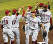  ?? MATT YORK / AP ?? The Cincinnati Reds celebrate Friday night’s extrainnin­gs win in Phoenix. The victory pushed them to a 6-1 record, the team’s best start since 1994.