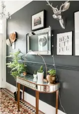  ??  ?? GRAND ENTRANCE In the hall, metallics and monochrome graphics stand out from the almost-black walls and complement the tiled floor. Farrow &amp; Ball has similar dark shades.